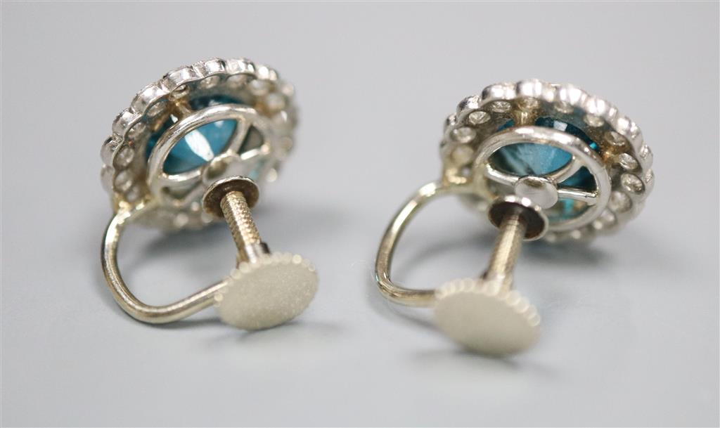 A pair of modern white metal, blue zircon and diamond cluster set circular ear clips, 11mm, gross 4.5 grams.